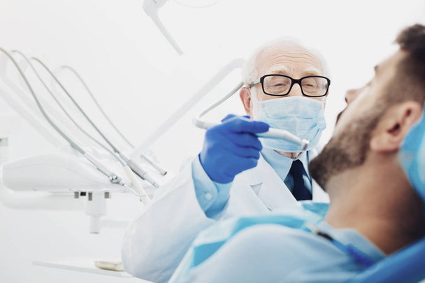 Experienced male dentist replacing tooth - Fotó, kép