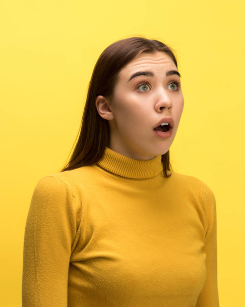 The woman screaming with open mouth isolated on yellow background, concept face emotion - Valokuva, kuva