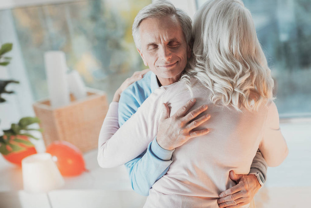 Cheerful elderly husband hugging his wife - Fotó, kép