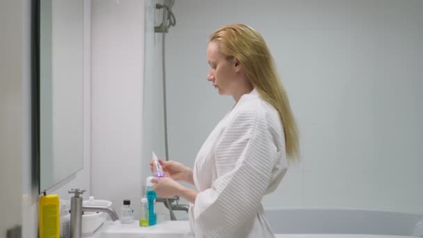 concetto di cura del viso. Donna che applica lozione cosmetica per prendersi cura della pelle in bagno. Igiene del mattino
 - Filmati, video