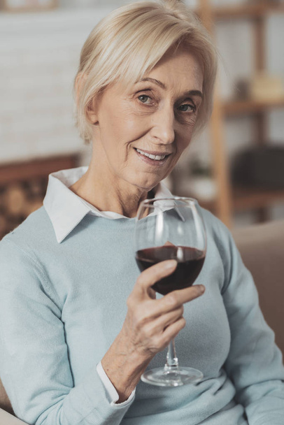 entzückte Seniorin bei einem Glas Wein - Foto, Bild