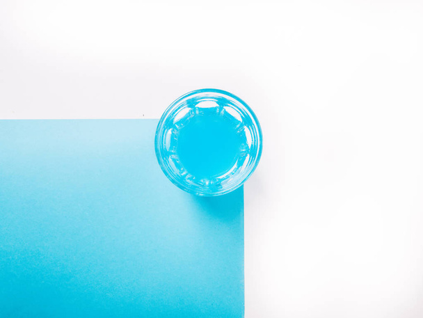 μπλε υγρό σε ένα ποτήρι με σε ένα μπλε και άσπρο φόντο - Φωτογραφία, εικόνα