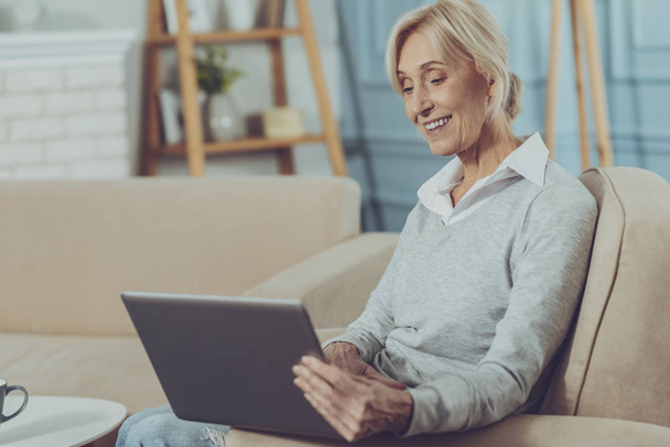 Elderly lady sitting with laptop - Foto, Bild