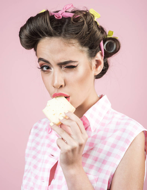 pretty girl in vintage style. pin up woman with trendy makeup. pinup girl with fashion hair. Healthy food and dieting. Farming. retro woman eating cheese. dairy products. tasty - Foto, Imagen