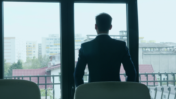 Empresário olhando para fora de sua janela do escritório
 - Filmagem, Vídeo