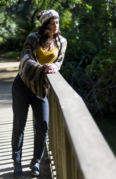 Beautiful woman on a wooden bridge in a park - Photo, image