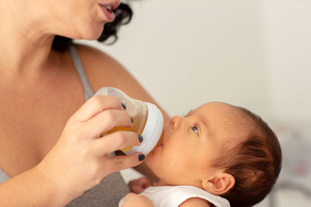 Anya ad-hoz iszik víz csecsemő baba fiú üveg - Fotó, kép