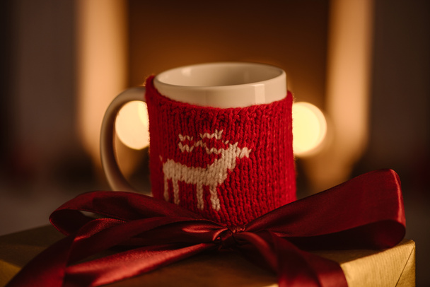 tasse tricotée actuelle et festive avec cerf sur fond flou
 - Photo, image
