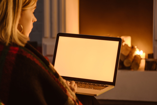 cropped view of young woman using laptop with blank screen at home - Fotoğraf, Görsel