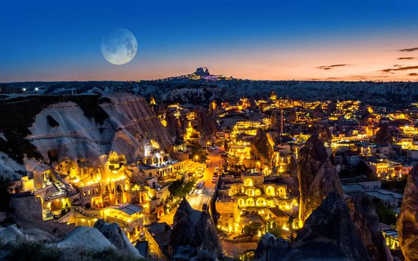 Paisaje nocturno del pueblo de Goreme, Turquía, con luna llena en el cielo
 - Foto, Imagen