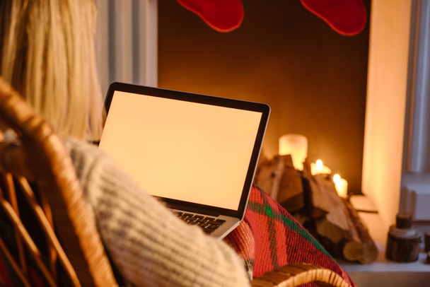vista recortada de la mujer usando el ordenador portátil con pantalla en blanco en casa
 - Foto, imagen
