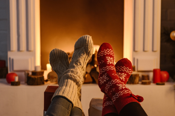 cropped view of women wearing winter socks with fireplace on background - Photo, Image