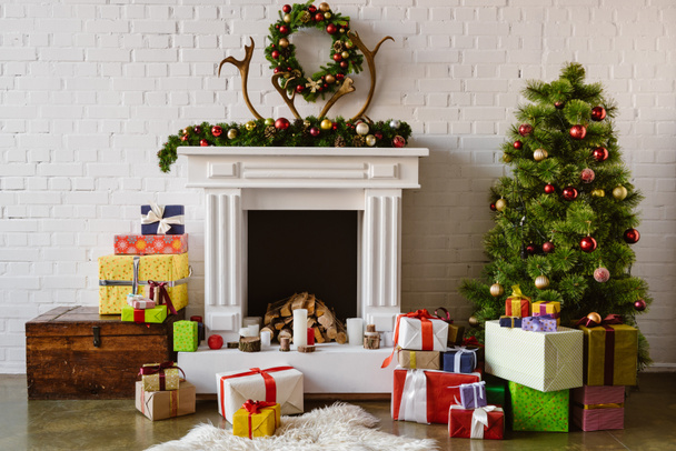 праздничная гостиная с уютным камином, елка и подарки
 - Фото, изображение