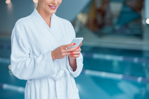 Cropped view of woman using smartphone near pool  - Foto, Imagen