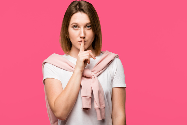 stylish woman looking at camera and doing silence gesture isolated on pink - Photo, Image