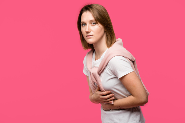 jeune femme ayant des douleurs à l'estomac isolé sur rose
 - Photo, image