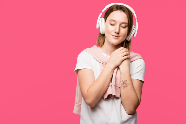 joyful young woman in headphones listening music isolated on pink - Photo, Image