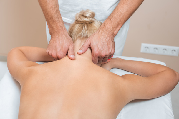 Massagista masculino fazendo massagem no pescoço no salão de spa
  - Foto, Imagem
