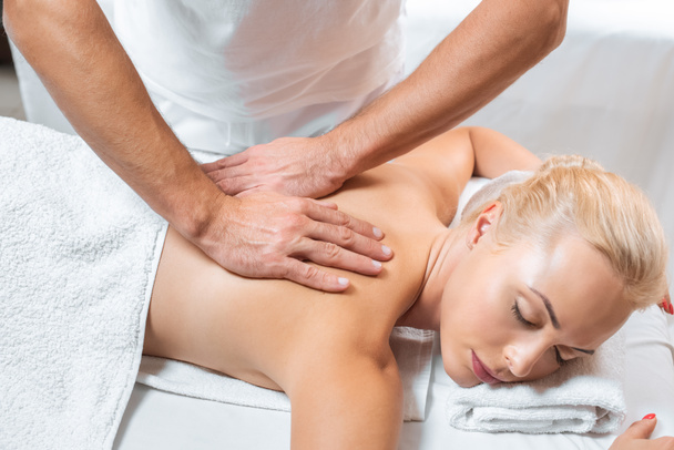 male masseur doing back massage to attractive woman in spa - Valokuva, kuva