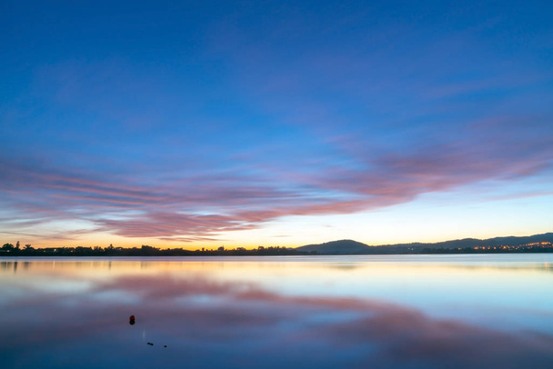 Calming effect of long exposure sunrise over bay in pink and blue hues. - Photo, Image