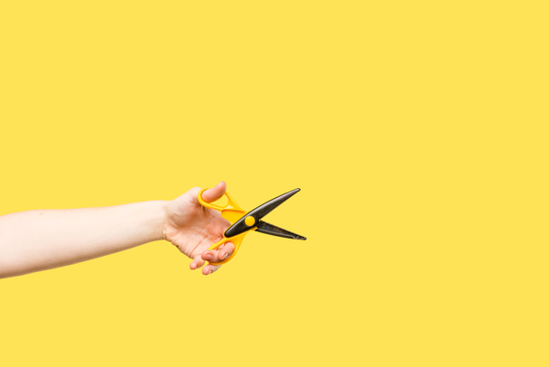 oříznuté shot osoby držící nůžky izolované na žluté - Fotografie, Obrázek