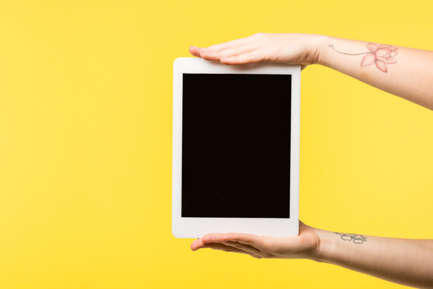 cropped shot of person holding digital tablet with blank screen isolated on yellow  - Photo, Image