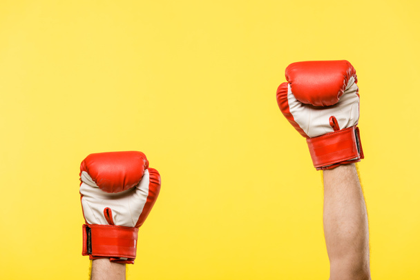 cropped shot of person in boxing gloves isolated on yellow  - Foto, Bild