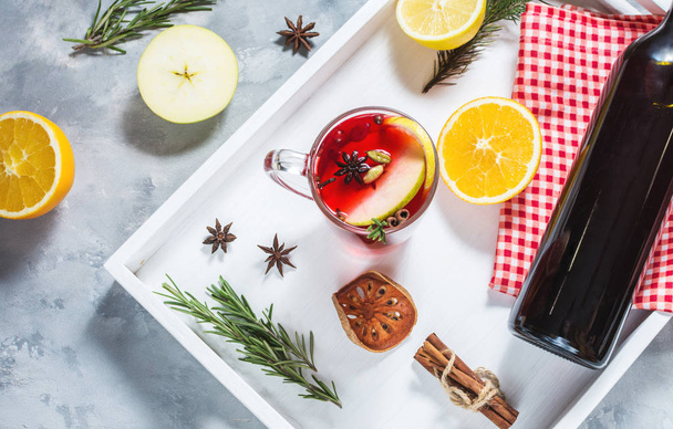 Mulled şarap, bir şişe kırmızı şarap, çam dalları, tarçın, portakal ve limon beton zemin üzerine beyaz tepsi. Kış içer. Noel arifesi - Fotoğraf, Görsel