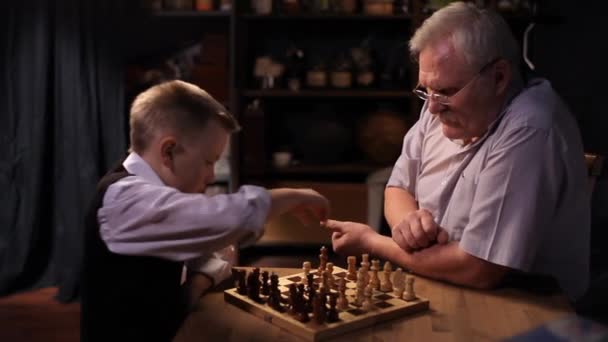 Happy grandfather plays chess with small grandson. - 映像、動画