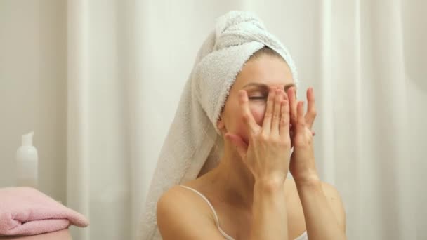 Hezká žena použití hydratační krém a masá obličeje po koupeli v místnosti. - Záběry, video