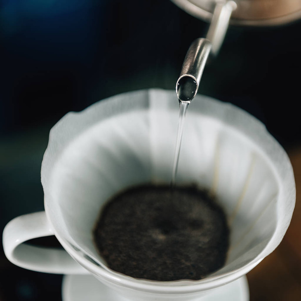 Закрыть квадратное изображение заливки кипящей воды из чайника в керамической капельной кофеваркой
.  - Фото, изображение