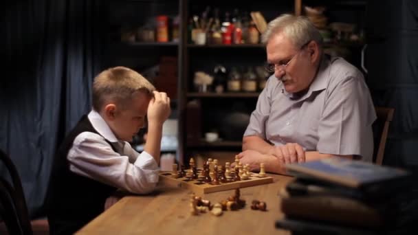 Gelukkig grootvader schaakt met kleine kleinzoon. - Video