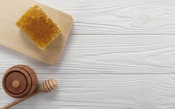 Honeycomb and wooden honey jar on table - Photo, Image