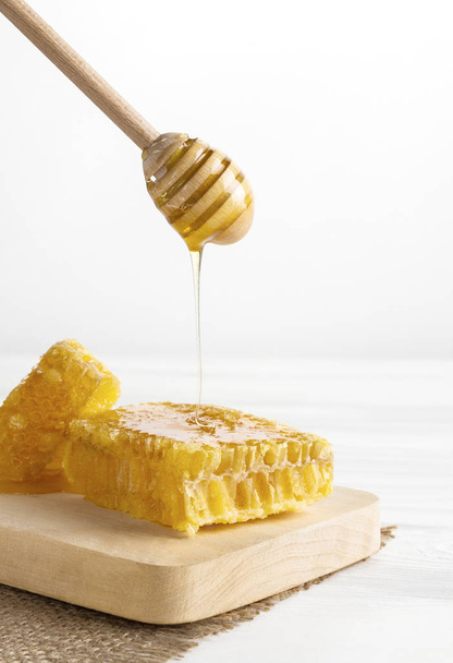 Honey dipping on natural honeycomb - Photo, Image