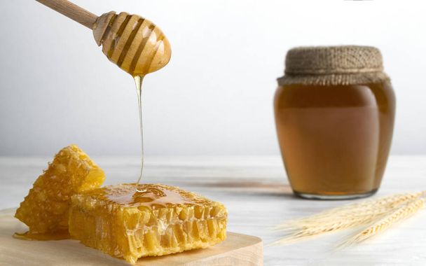Osa de miel y panal sobre mesa de madera
 - Foto, imagen