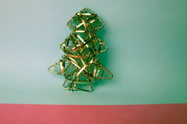 Natal festivo Natal feliz azul-rosa fundo alegre com um pequeno brinquedo metal ferro dourado caseiro árvore de Natal. Decorações de férias
 - Foto, Imagem