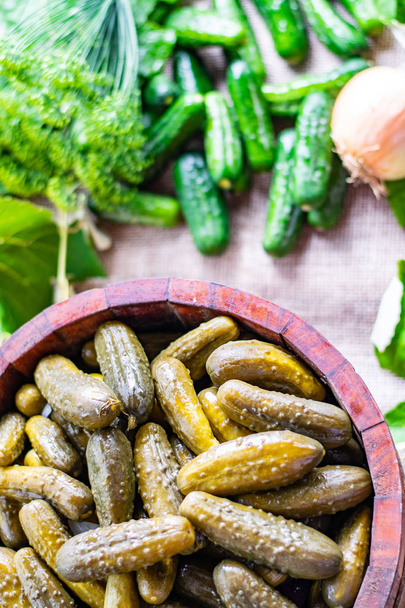Preserved pickled cucumbers with dill and  onions in a wooden barrel - Photo, Image