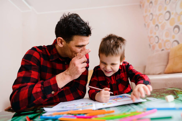 Jeune concentré père et fils dessin à la maison
 - Photo, image