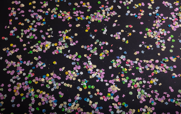 Carnaval o fiesta de cumpleaños. Colorido confeti sobre fondo negro, vista superior
 - Foto, imagen