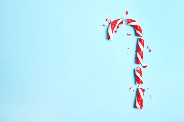 Broken candy cane and space for text on color background, top view - Фото, зображення