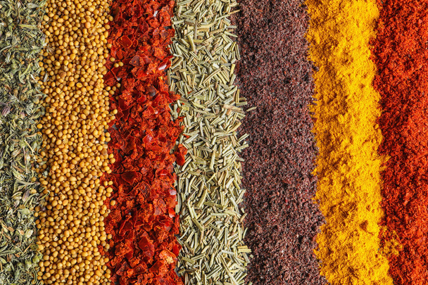 Rows of different aromatic spices as background, top view - Foto, immagini