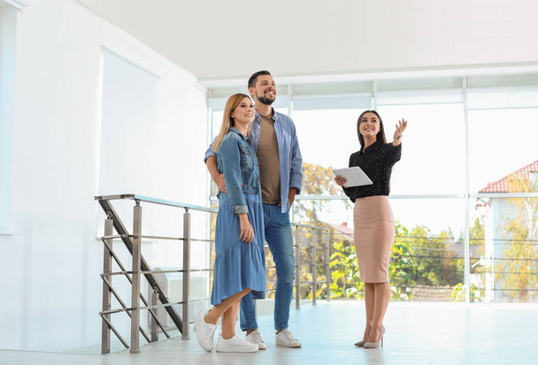 Female real estate agent showing new house to couple, indoors - Foto, Bild