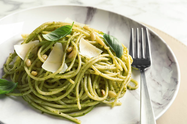 Plate with delicious basil pesto pasta on table, closeup - Valokuva, kuva