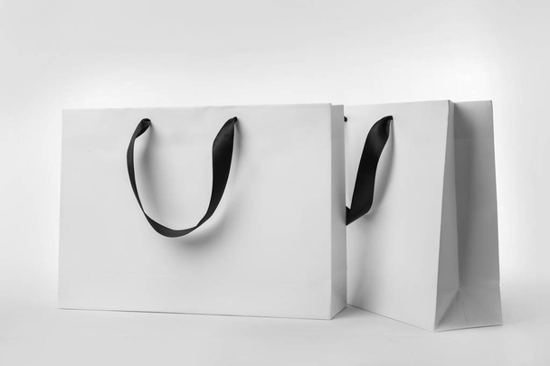 Paper shopping bags with ribbon handles on white background. Mockup for design - Foto, immagini