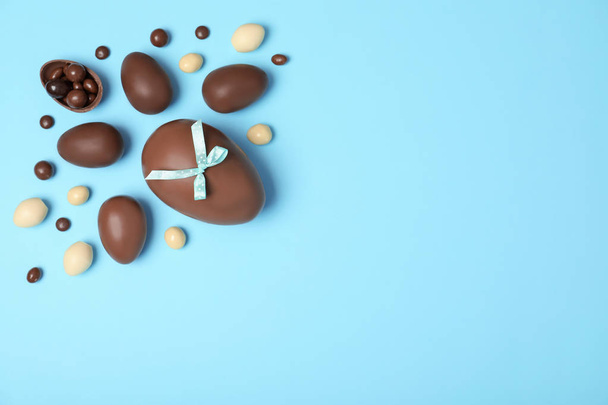 Composizione di posa piatta con uova di Pasqua al cioccolato e spazio per testo su sfondo a colori
 - Foto, immagini
