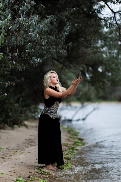 plajda uzun siyah elbiseli güzel genç kadın - Fotoğraf, Görsel