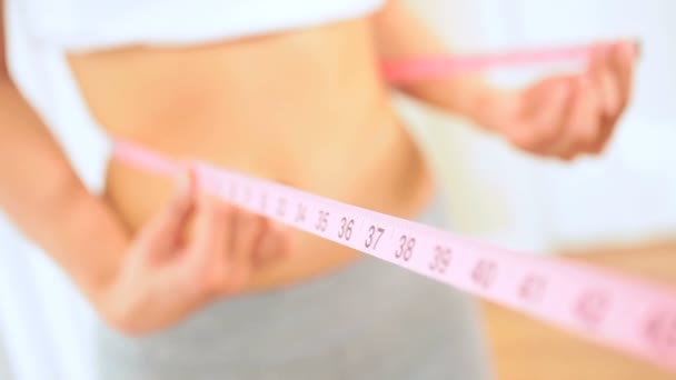 Jovem fêmea usando fita de medição da cintura
 - Filmagem, Vídeo