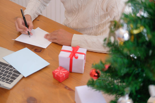 hombre vistiendo suéter crema escritura navidad carta felicitación tarjeta vacaciones deseos con decoración de Navidad
. - Foto, imagen