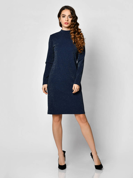Young beautiful woman posing in new dark  blue fashion winter dress on a white - Photo, image