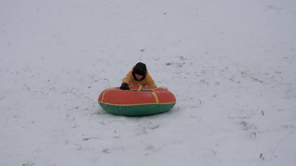 nieve de invierno divertido. niños montan un tubo desde una diapositiva
. - Metraje, vídeo
